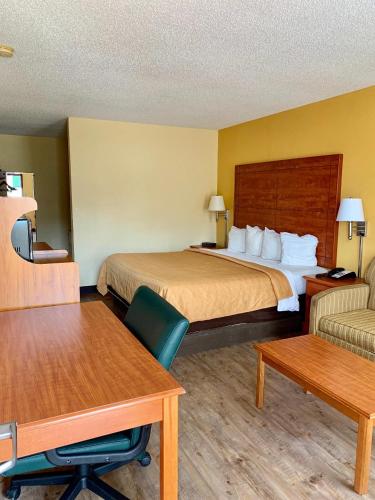 MagnoliaCoachman's Inn的酒店客房配有床、沙发和桌子。