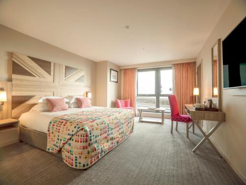 布莱克浦Boulevard Hotel的酒店客房配有一张床、一张书桌和一台电视。