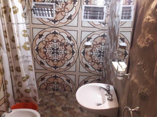 圣奥古斯汀镇Cabañas Laukan的一间带水槽和卫生间的浴室以及瓷砖墙