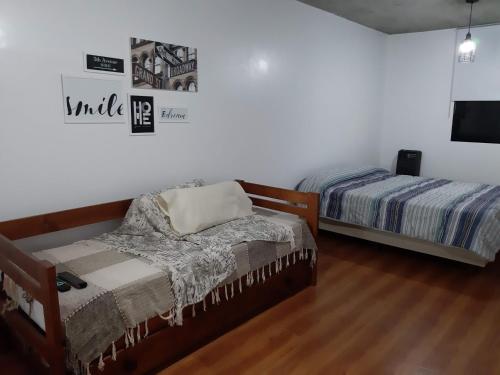 拉普拉塔Depto calle 20 y 37 - monoambiente, muy bonito y luminoso!的一间卧室设有两张床,墙上配有电视。