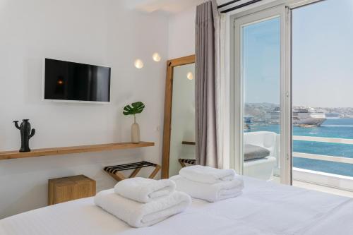 圣斯特凡诺斯Obsession Mykonos的一间卧室设有一张床,享有海景