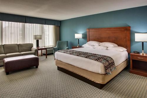 休斯顿Sonesta Essential Houston Hobby Airport的酒店客房带一张大床和一把椅子