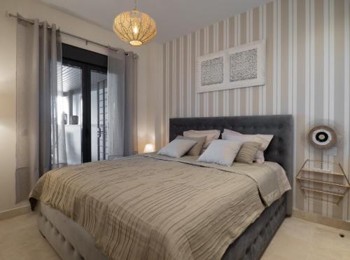 EsteponaAmazing Two Bedroom Apartment in Los Flamingos, Marbella的一间卧室配有一张大床和一个吊灯。
