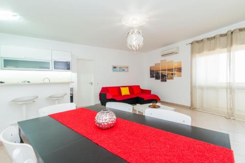 夫塞塔Apartamento Praia Fuzeta的客厅配有黑桌和红色地毯