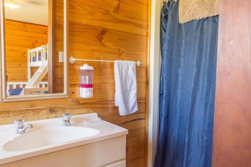 怀托摩洞穴JunoHall Backpackers的一间带水槽和镜子的浴室