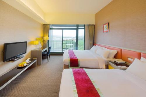 台东娜路弯花园酒店 的酒店客房设有两张床和一台平面电视。