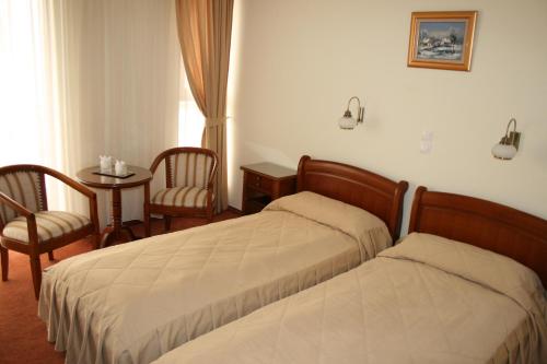 德瓦萨尔米斯酒店的酒店客房带两张床和一张桌子以及椅子。