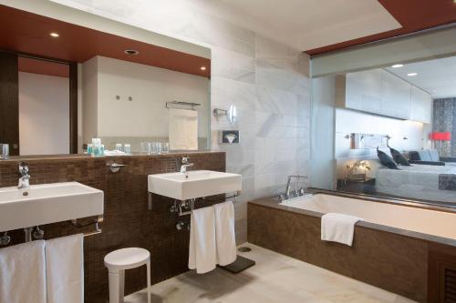 科尼尔-德拉弗龙特拉格兰康尼尔水疗时尚酒店的一间带两个盥洗盆和大镜子的浴室