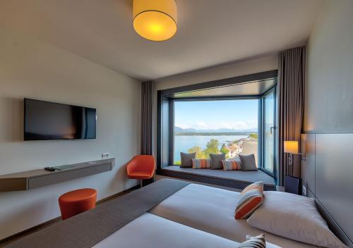 韦尔苏瓦Lake Geneva Hotel的酒店客房设有一张床和一个大窗户