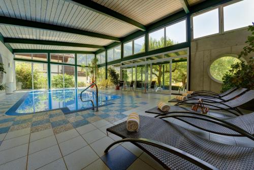 弗拉塔赫弗拉特施霍夫酒店的一座带椅子的游泳池和一座游泳池