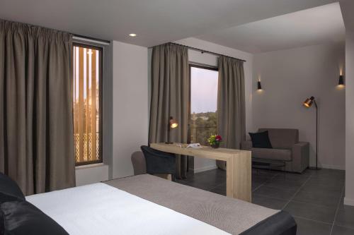 雅典Azur Suites的酒店客房带一张床、一张桌子和椅子