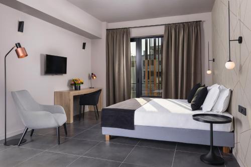 雅典Azur Suites的卧室配有1张床、1张桌子和1把椅子