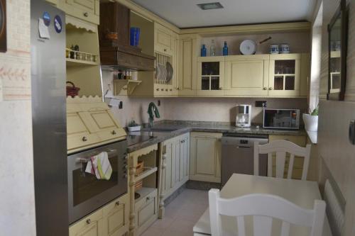 曼西利亚德拉斯穆拉斯MENCIA的厨房配有黄色橱柜和炉灶烤箱