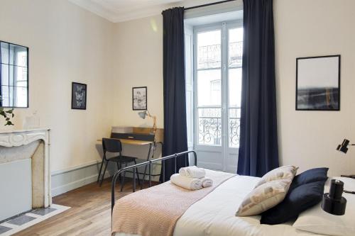 南特Sous Le Cèdre - Au cœur de Nantes的一间卧室配有一张床、一个窗口和一张书桌
