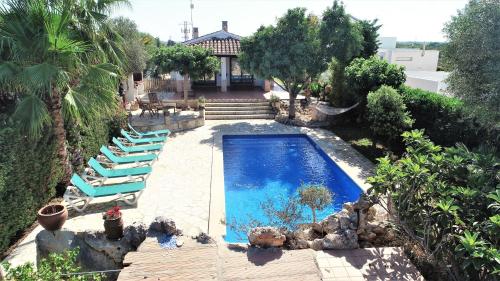 休达德亚Villa para 6 con piscina privada.的一个带躺椅的游泳池以及一座房子