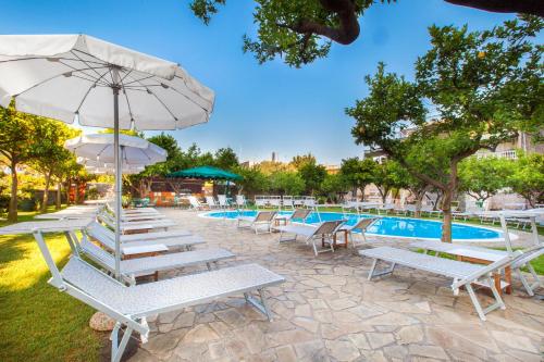 索伦托安蒂奇米拉酒店的一组躺椅和一把遮阳伞,位于游泳池旁
