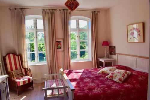巴斯托夫Alte Büdnerei的一间卧室配有红色的床、椅子和窗户