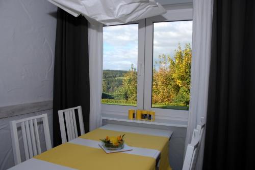 KröppenHaus Kölsch的一间设有黄色桌子和窗户的客房