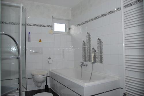 KröppenHaus Kölsch的白色的浴室设有浴缸和卫生间。