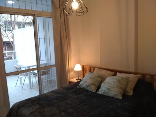 罗萨里奥莫雷诺1330公寓的一间卧室设有一张床和一个大窗户