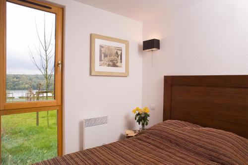 埃普索瓦日维洛利小屋节日夫人酒店的一间卧室设有一张床和一个大窗户