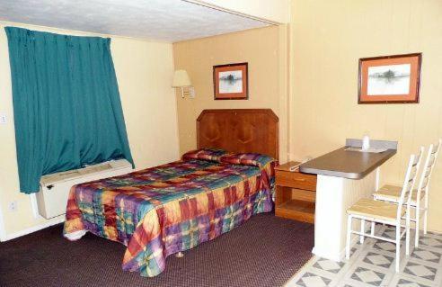 Wills Point州际公路汽车旅馆的配有一张床和一张书桌的酒店客房