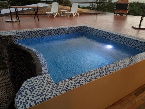 纽沃阿雷纳尔Casa Donna Rosa B&B的蓝色的水和白色瓷砖游泳池
