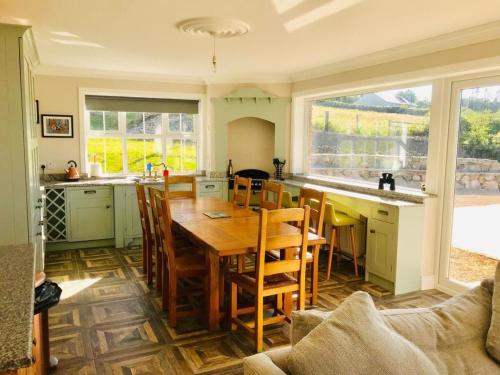 Ó MéithMaggie janes cottage Carlingford omealth的一间厨房,内设一张木桌和椅子