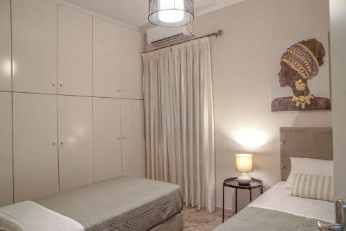 扎金索斯镇Arkadins的一间卧室配有两张床和一盏灯及窗帘