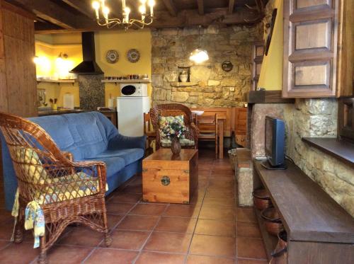 Ceceda de AbajoLa Foina的一间带蓝色沙发的客厅和一间厨房