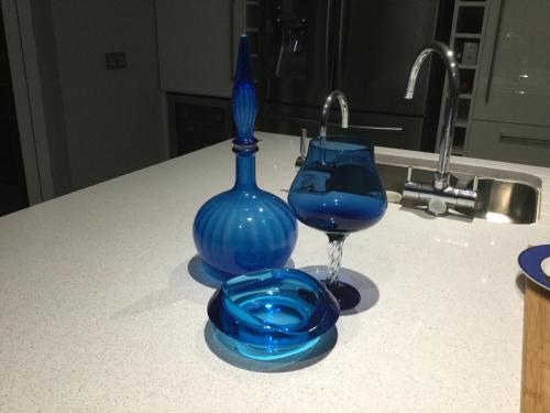 伦敦德里五棵橡树酒店的蓝色玻璃瓶和吧台上的葡萄酒杯