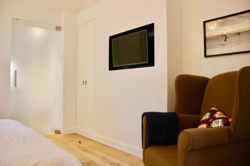 根特Bennestay的卧室配有沙发和电视。