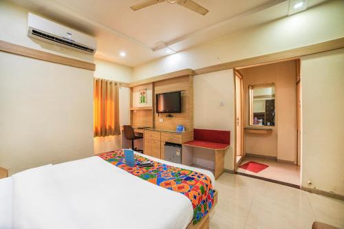 印多尔FabHotel Santoor Geeta Bhawan Square的酒店客房,配有床和电视