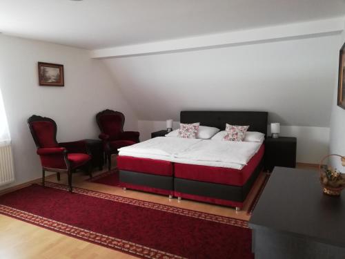 图尔钱斯凯特普利采熊猫2号旅馆的一间卧室配有一张床和两张红色椅子