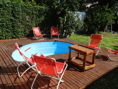 布宜诺斯艾利斯B&B Polo的一组椅子和一张桌子,旁边是游泳池