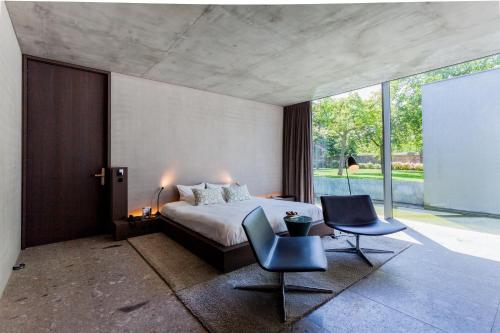 迪克斯梅德诺特利胡斯“纯美”酒店的一间卧室配有一张床和两把椅子