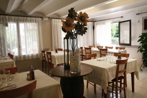 Sant Privat de Bas卡梅莉塔酒店的花瓶里带桌椅的餐厅