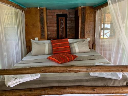 金贾Samuka Island Retreat的一张床上有两个枕头的房间