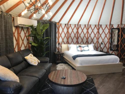 埃斯卡兰特Escalante Yurts - Luxury Lodging的蒙古包内带一张床和一张沙发的房间