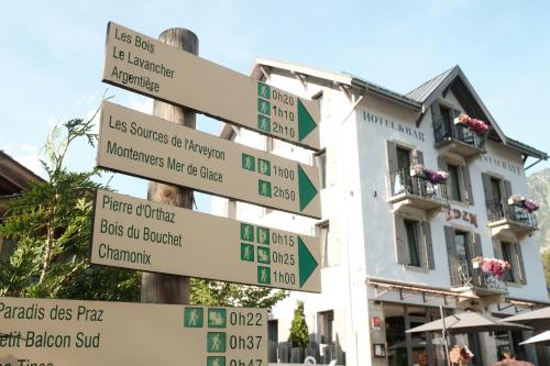夏蒙尼-勃朗峰Eden Hotel, Apartments and Chalet Chamonix Les Praz的建筑前有路标的柱子