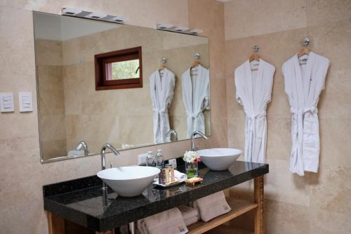 库斯科Tocuyeros Boutique Hotel的一间带两个盥洗盆和大镜子的浴室