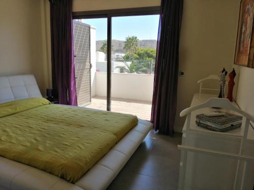 阿瓜阿马加CASA LA ROCA的一间卧室设有一张床,享有阳台的景色