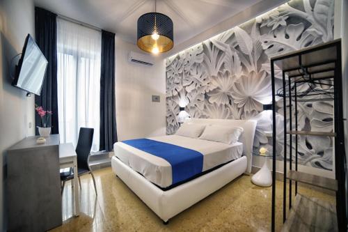 那不勒斯Le Corti del Re的一间卧室配有一张床、一张书桌和一台电视。