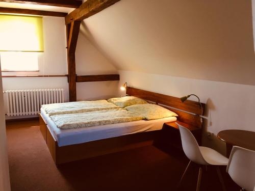 蒂萨宇比托法尼朵玛酒店的卧室配有一张床和一张桌子及椅子