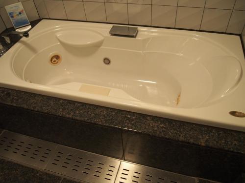 KunitachiHotel Cherena Kunitachi (Adult Only)的白色浴缸位于柜台上