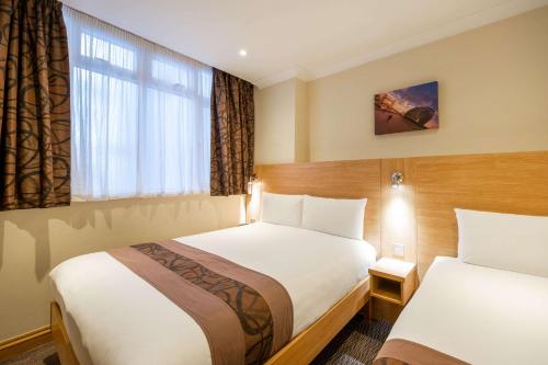 伦敦海德公园卡姆福特酒店的酒店客房设有两张床和窗户。