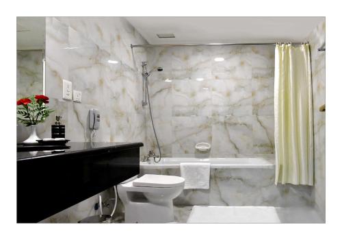 麦纳麦海湾大门酒店的浴室配有盥洗盆、卫生间和浴缸。