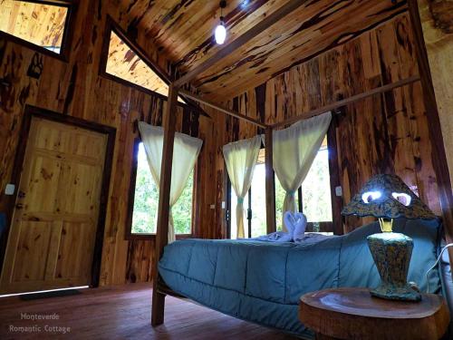 蒙泰韦尔德哥斯达黎加Monteverde Romantic Cottage的小木屋内一间卧室配有蓝色沙发