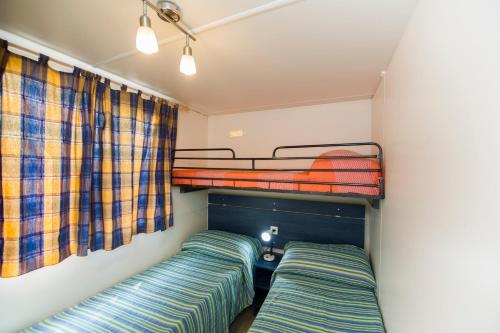 维亚雷焦Camping La Pineta的一间卧室设有两张双层床和一扇窗户。