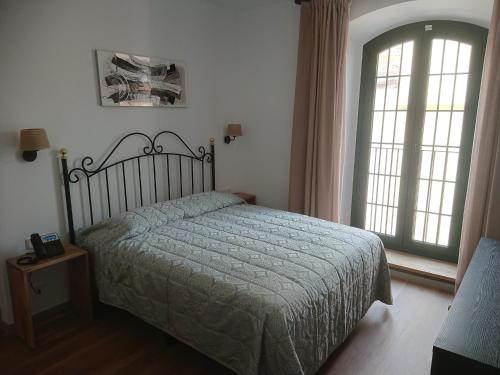 莱斯卡拉Jardi de Pedra的一间卧室设有一张床和一个大窗户